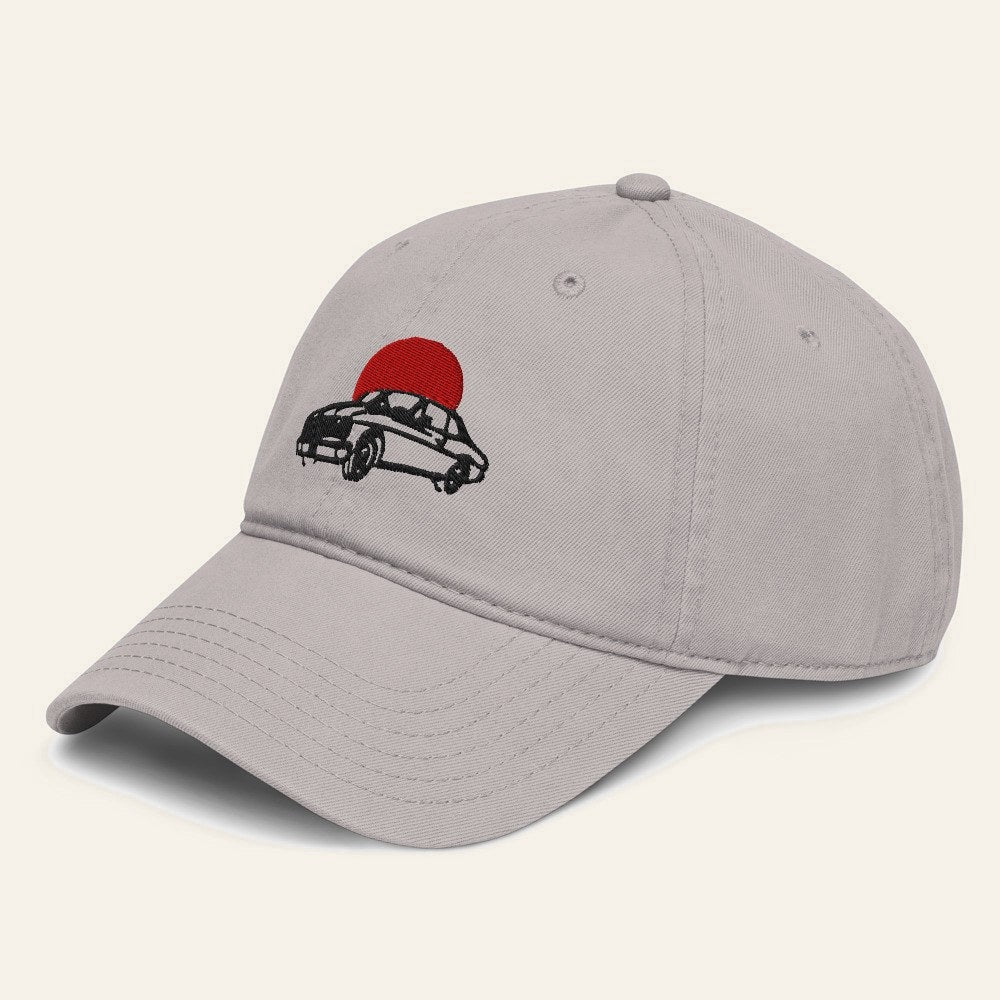 The Del Barrio Cap in Gray, angle. Lowrider and sun in black and red thread.