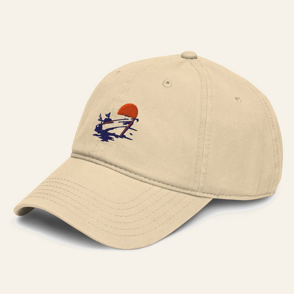 The Del Mar Cap in Khaki, angle. Boat and sun in navy and orange thread.